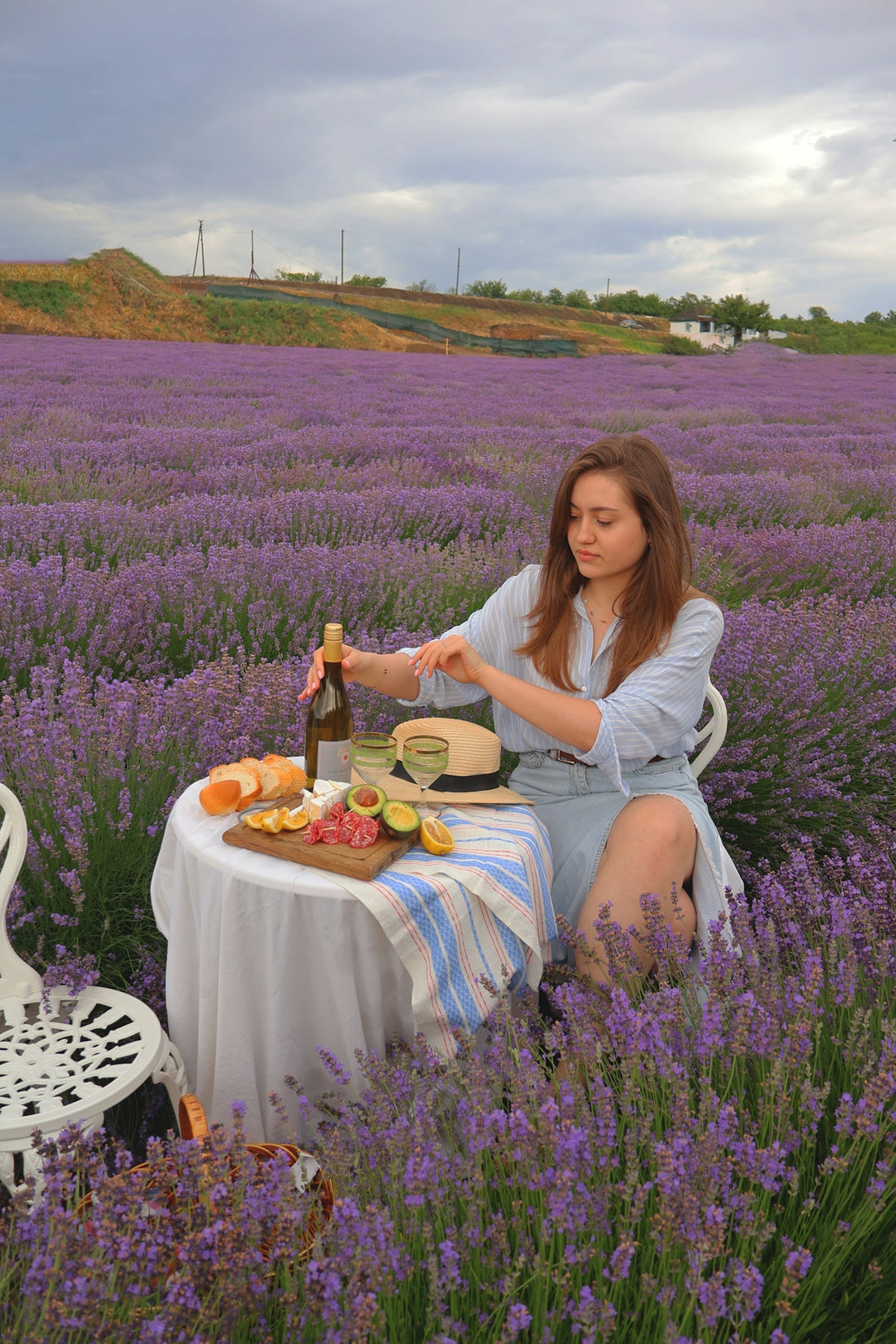 a woman sitting at a table in a lavender field