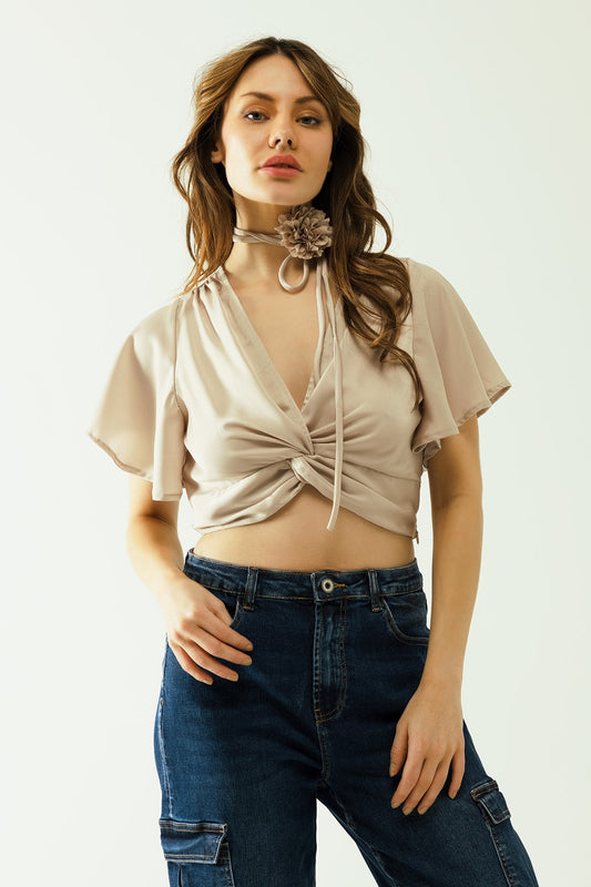 Beige V-neck crop top with short sleeves and a flower detail on the neck - Tops