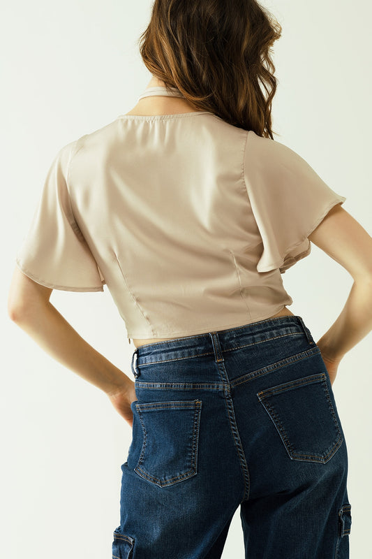 Beige V-neck crop top with short sleeves and a flower detail on the neck - Tops