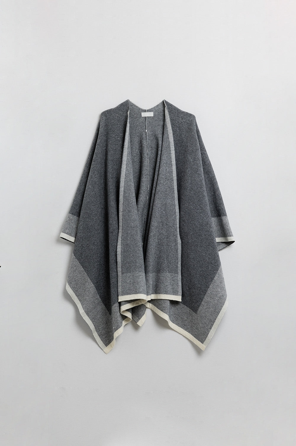 Poncho tricoté gris avec bordure écrue